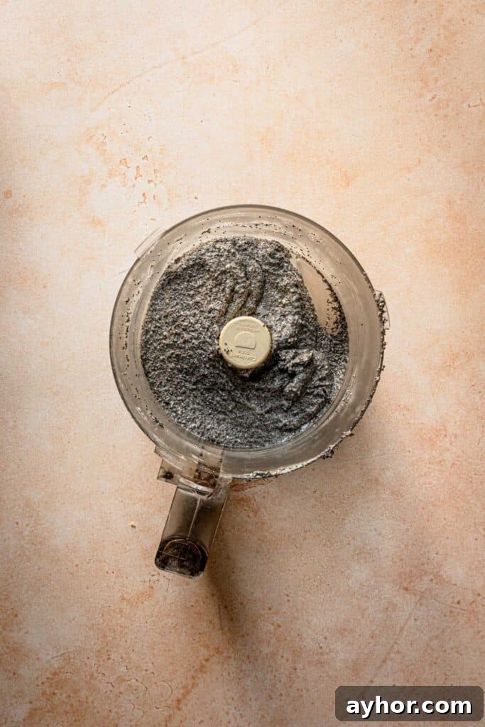 Poppy seeds filling in a bowl of a food processor.
