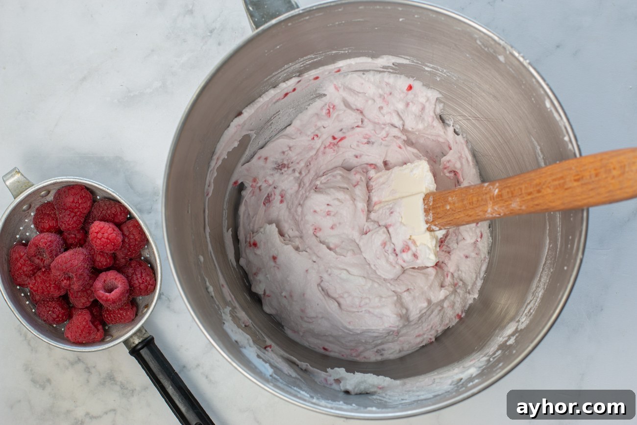 Add fresh raspberries to whipped coconut cream