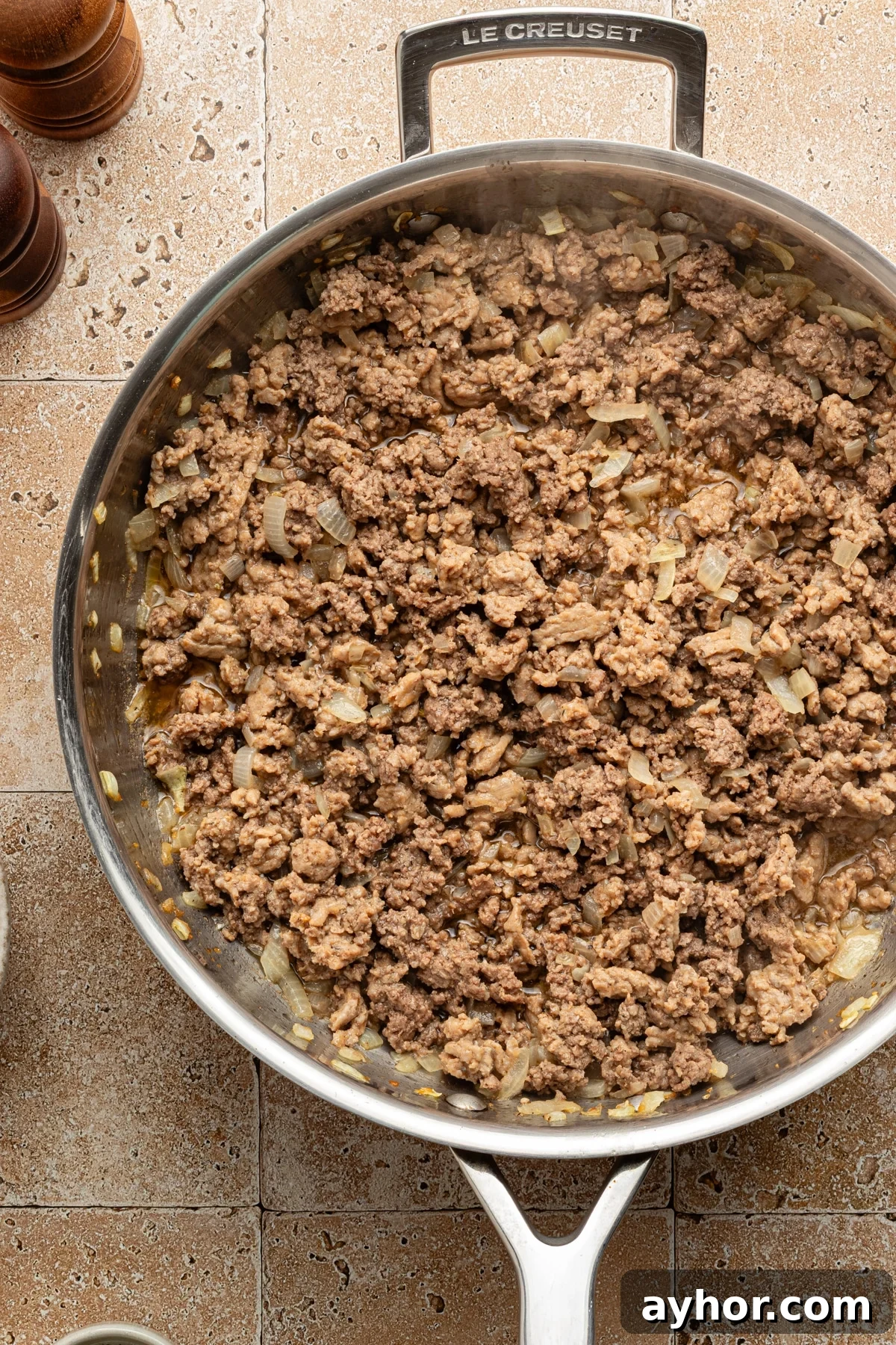 High-Protein Baked Ziti Recipe for Muscle & Meal Prep 4 Ground beef and turkey sausage crumbles cooked in a large skillet with onions and garlic.