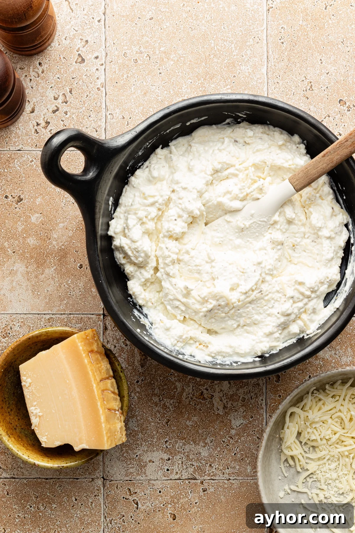 High-Protein Baked Ziti Recipe for Muscle & Meal Prep 6 Cottage cheese, mozzarella and parmesan mixed in a bowl.