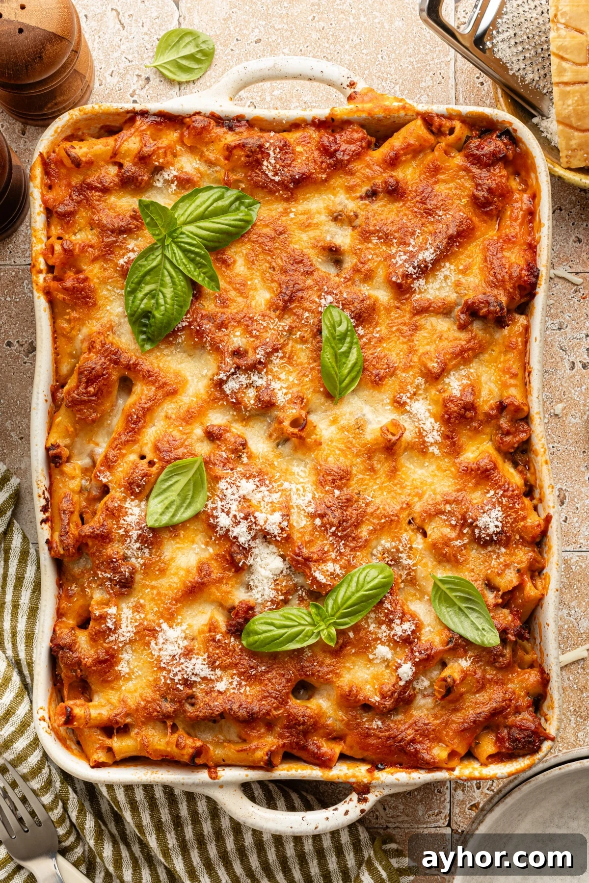 High-Protein Baked Ziti Recipe for Muscle & Meal Prep 10 High protein baked ziti in a casserole dish garnished with fresh basil leaves.