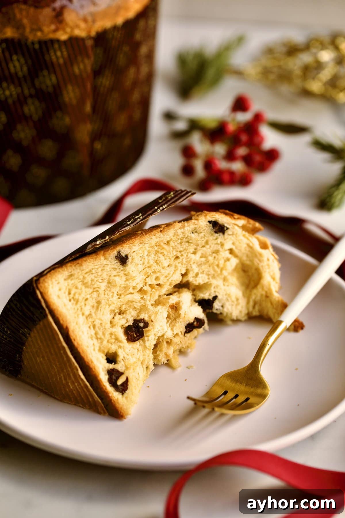 Classic Italian Panettone Recipe: Authentic Holiday Sweet Bread 21 slice of panettone on a plate with Christmas decorations in the background