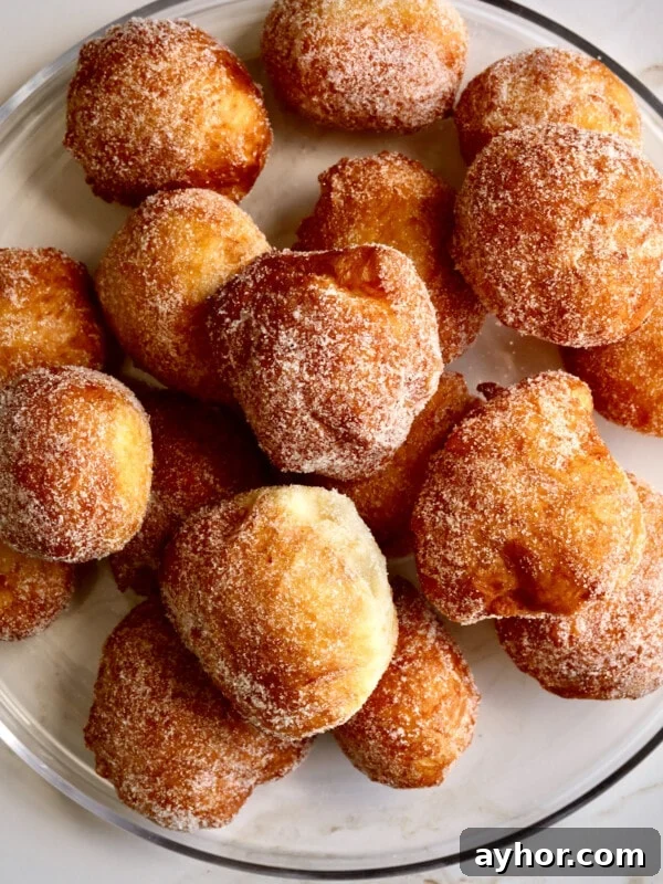 Classic Italian Panettone Recipe: Authentic Holiday Sweet Bread 23 Zeppole donuts piled on a plate.