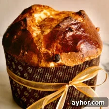 Classic Italian Panettone Recipe: Authentic Holiday Sweet Bread 26 Panettone in a paper wrapper tied with a bow.