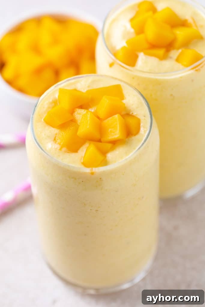 Creamy Mango Banana Smoothie Recipe for Tropical Energy 2 Two glasses filled with mango and banana smoothie.