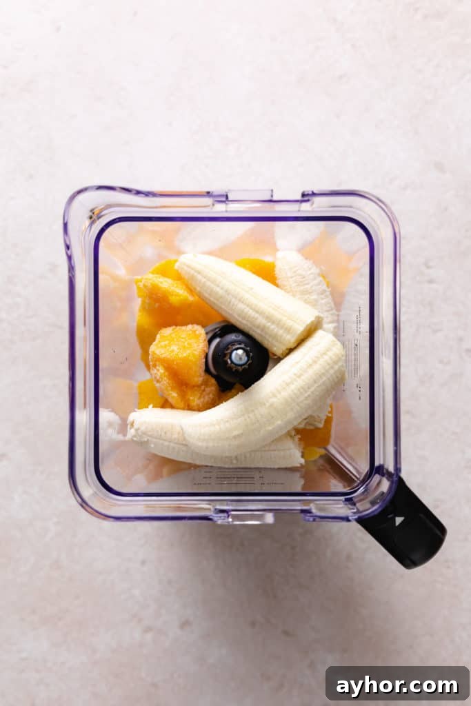 Creamy Mango Banana Smoothie Recipe for Tropical Energy 3 Banana, frozen mango, and milk in a blender.