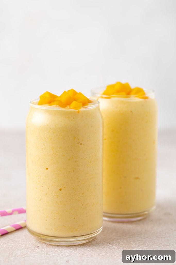 Creamy Mango Banana Smoothie Recipe for Tropical Energy 5 Side view of a mango banana smoothie in a glass.