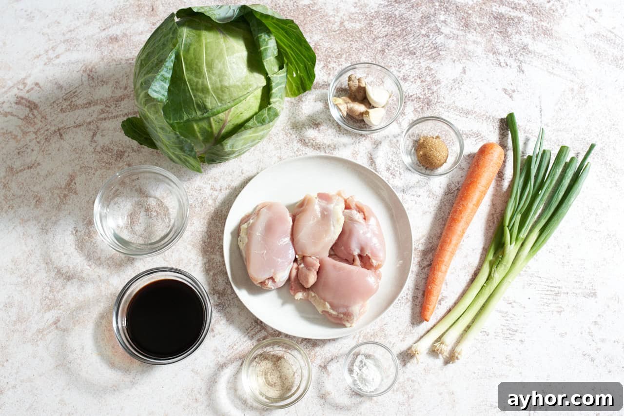 A head of cabbage, a carrot, some scallions, a plate of chicken thighs and small bowls of soy sauce, rice vinegar, water, corn starch, brown sugar, and garlic cloves.