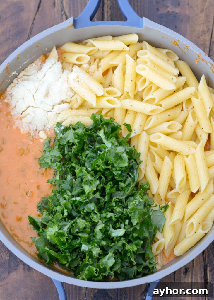 This Sausage and Butternut Squash Pasta features a creamy, lightened up pasta sauce, fresh kale and browned Italian sausage. This is the perfect family friendly dinner recipe that is ready in about 30 minutes! 