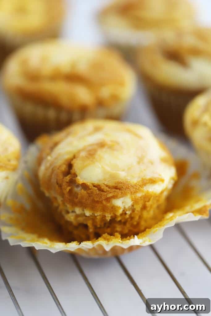 A wire rack full of pumpkin cheesecake muffins.