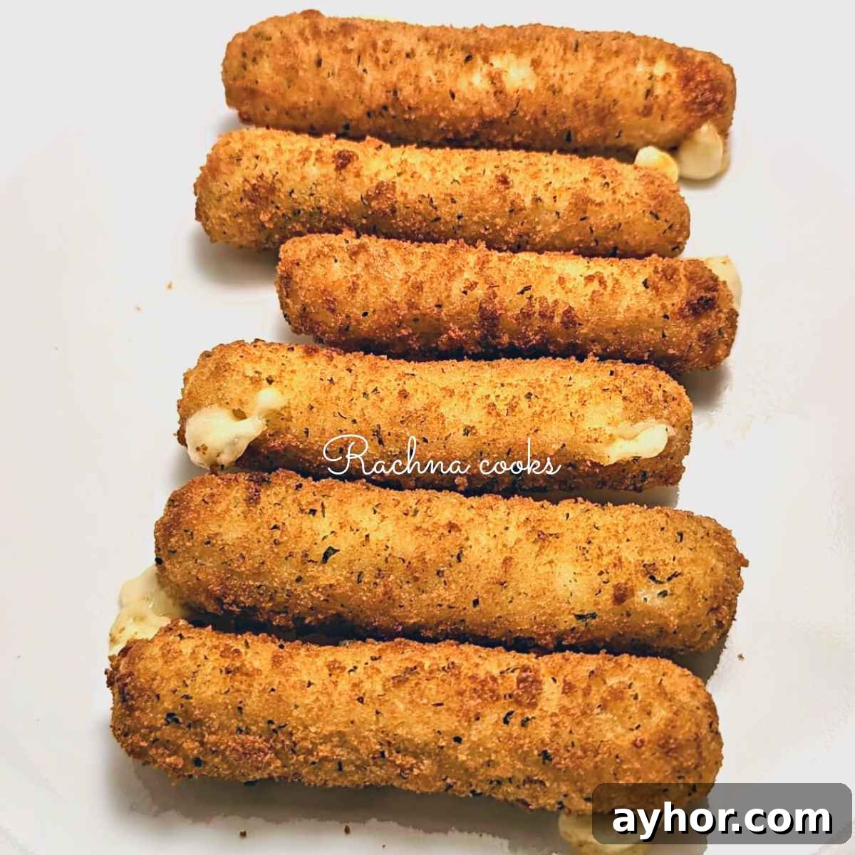 Crispy air fried mozzarella sticks served on a white plate