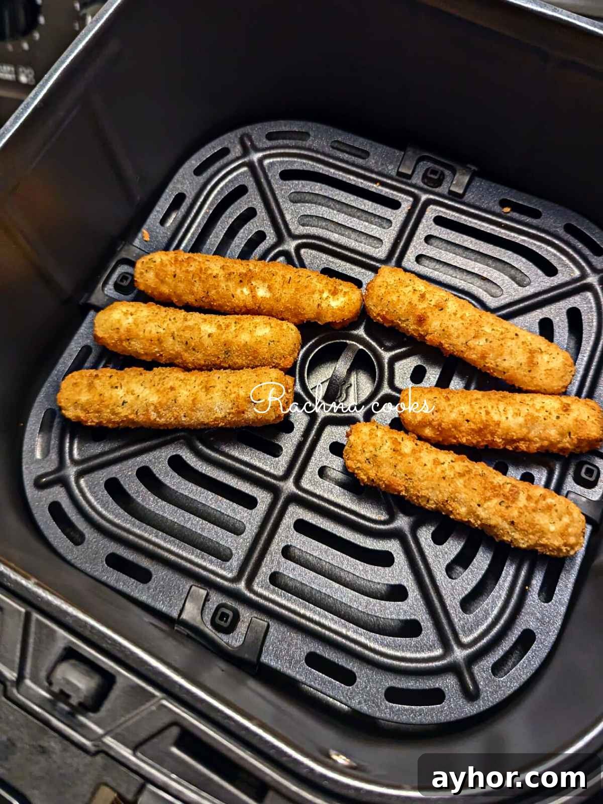 Mozarella sticks placed in air fryer basket.