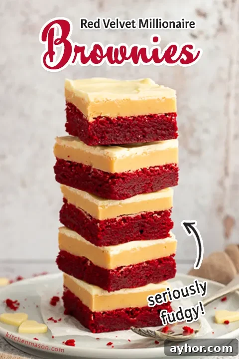 A stack of 5 red velvet millionaire brownies set on two stacked plates with a fork on the side.