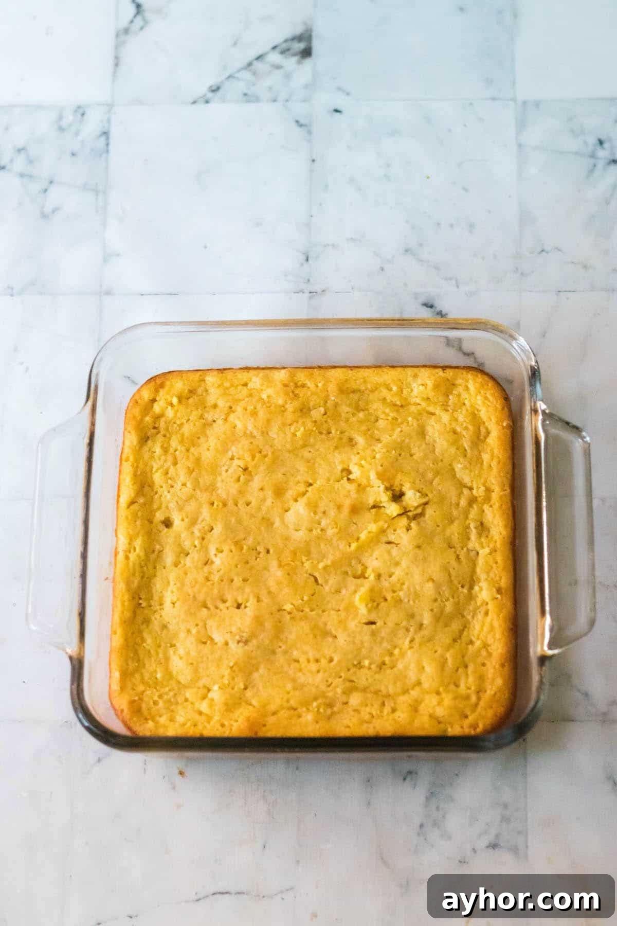 Baked cornbread in a square casserole dish.