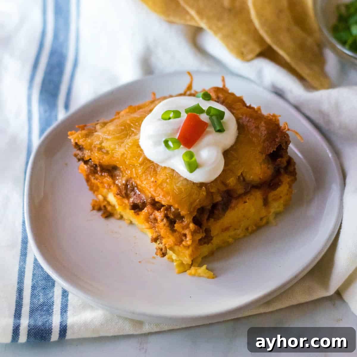 Cheesy cowboy cornbread casserole topped with a dollop of sour cream.