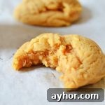 Brown Butter Pumpkin Spice Cookies Recipe for Fall Gatherings 5 a brown butter pumpkin spice cookie with a bite missing on parchment paper