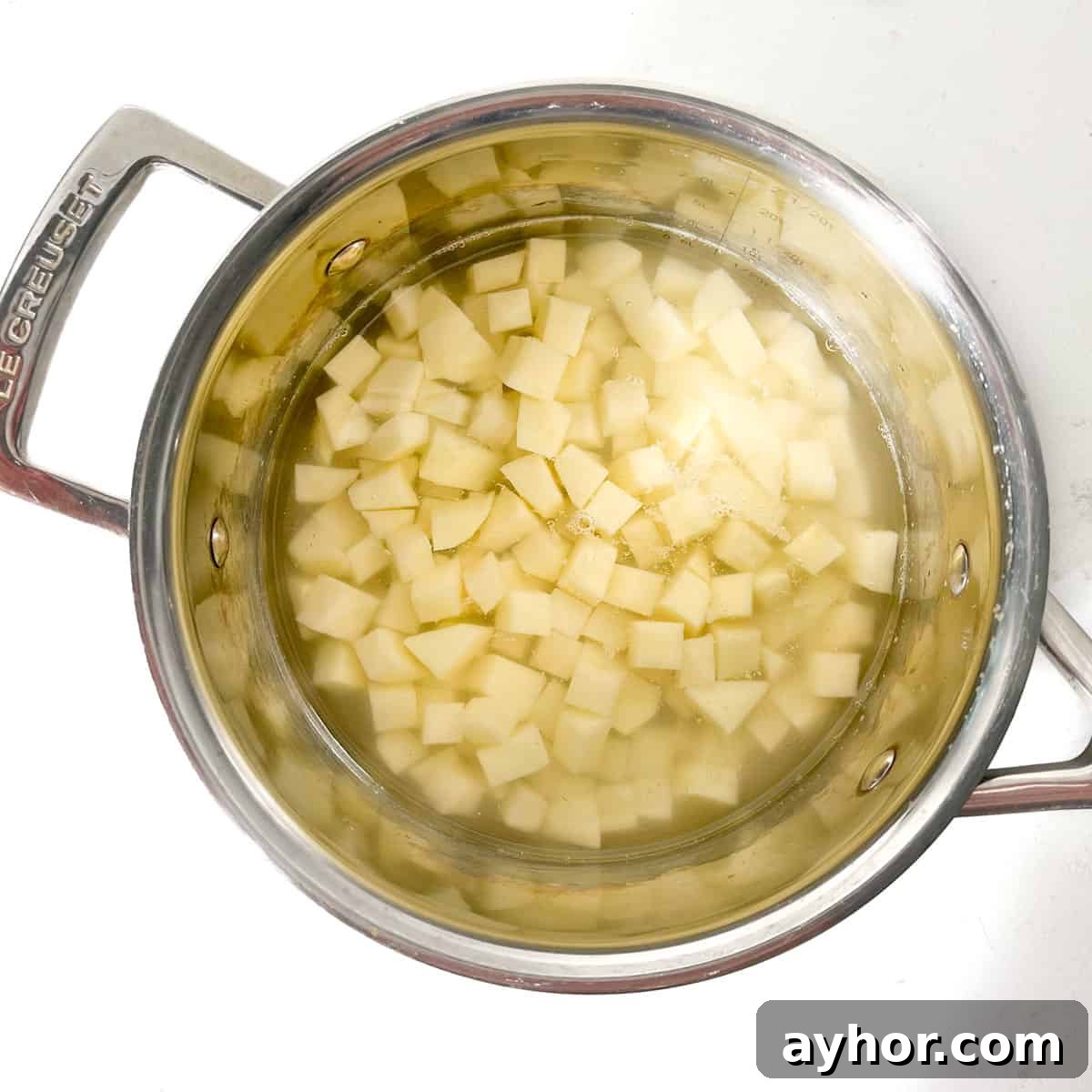 Potato cubes in a saucepan, covered with water. 