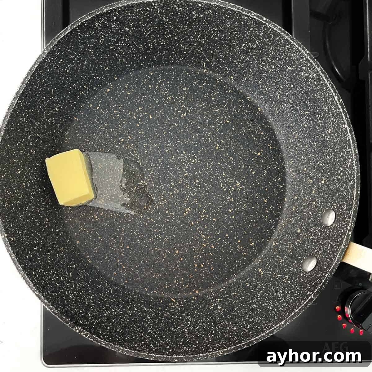 Adding butter to a large frying pan to melt.