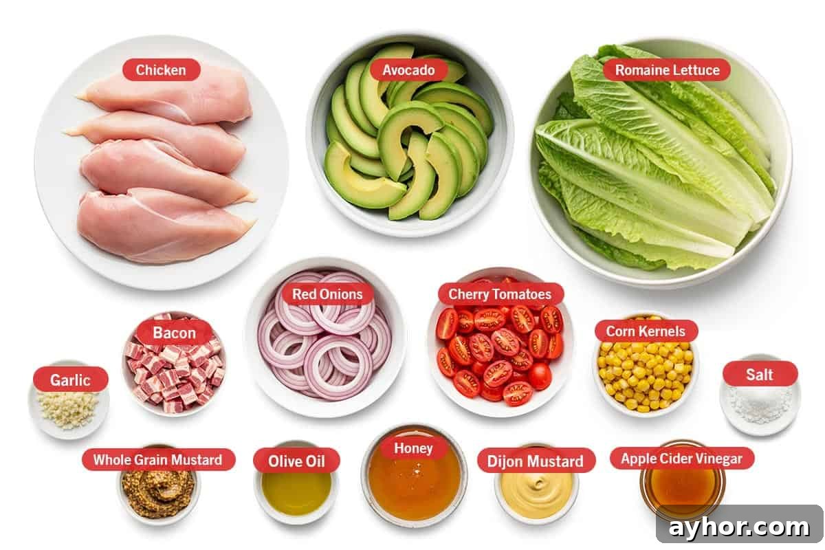 Top shot of ingredients: Chicken, avocado, Romaine lettuce, garlic, bacon, red onion, cherry tomatoes, corn kernels, salt, whole grain mustard, olive oil, honey, Dijon mustard, and apple cider vinegar