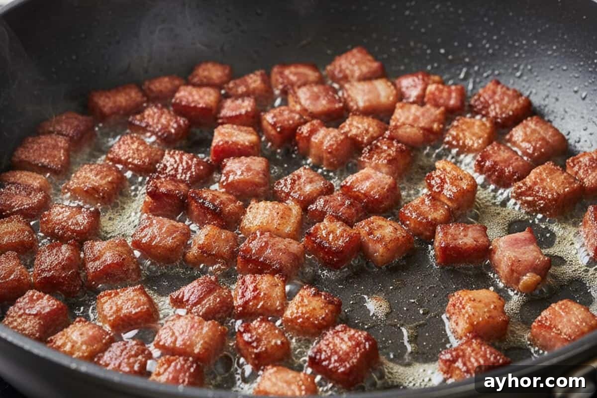 Frying the diced bacon until crispy.