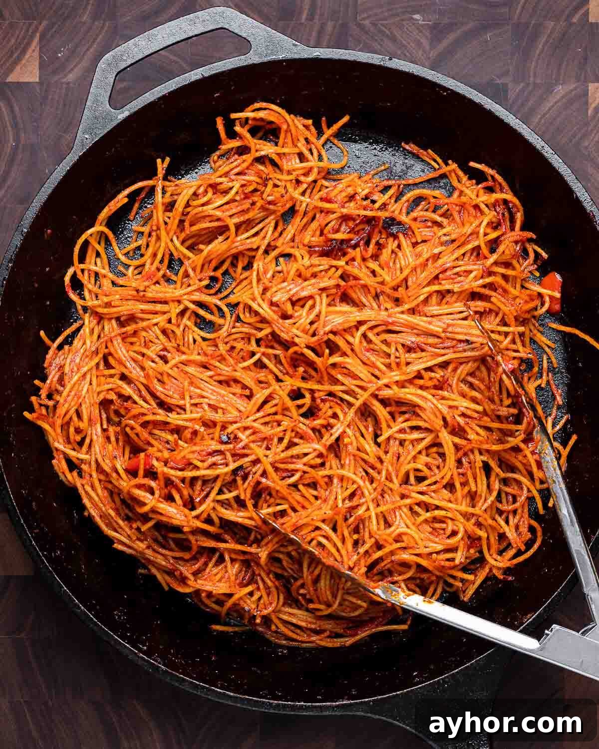 Podcast 33: Essential Kitchen Tools Every Cook Should Own 3 Assassin's pasta in large cast iron pan on walnut cutting board.