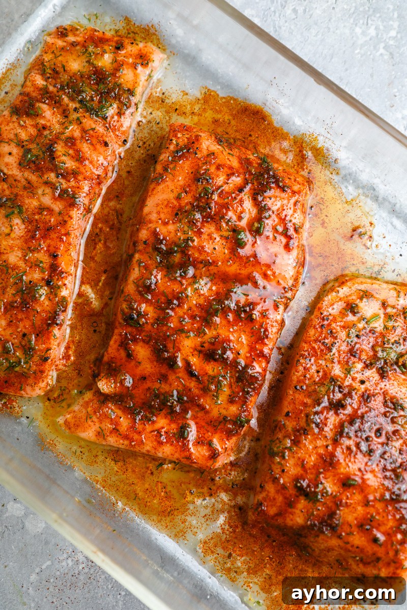 Baked Salmon with Creamy Avocado and Feta Crumble 5 3 salmon fillets sitting in baking dish brushed with lemon and dill and seasoned with salt, black pepper and paprika
