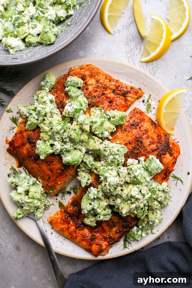 Baked Salmon with Creamy Avocado and Feta Crumble 7 A small plate filled with lemon and dill baked salmon topped with avocado and feta