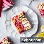 Lemon Rhubarb Bars Recipe with Buttery Shortbread Crust 10 Lemon rhubarb bar on a white plate.