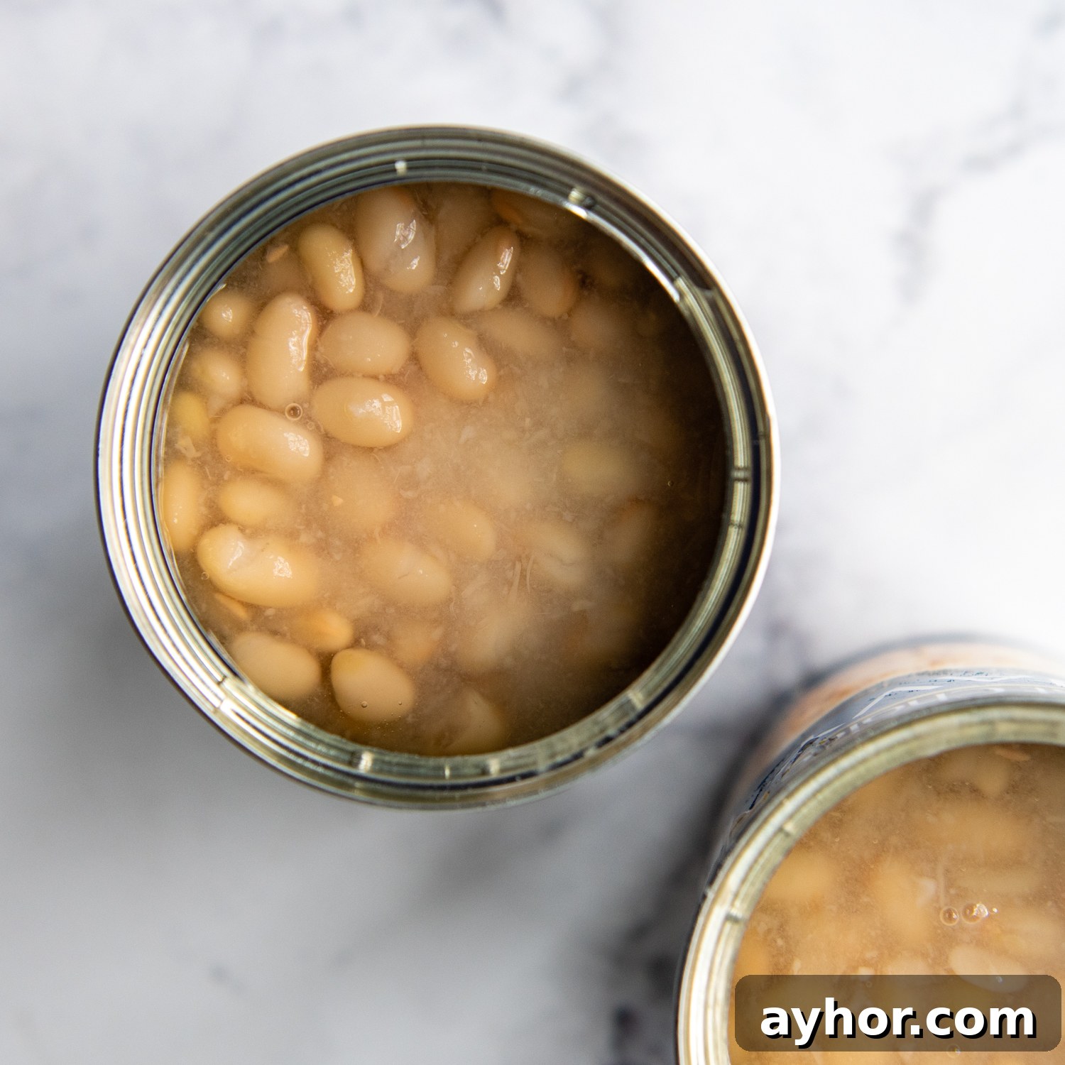 an open can of beans, partially drained.