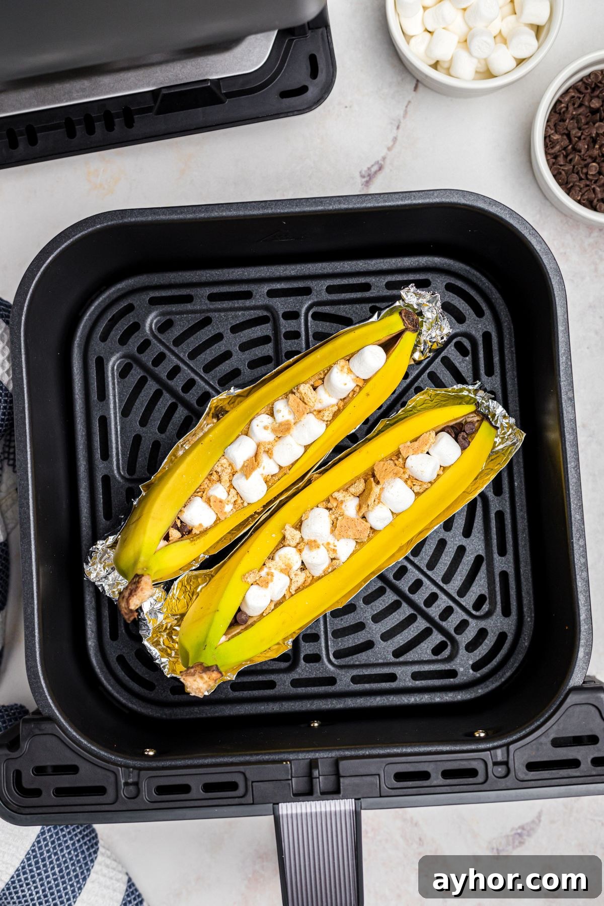 banana boats on foil in air fryer basket.