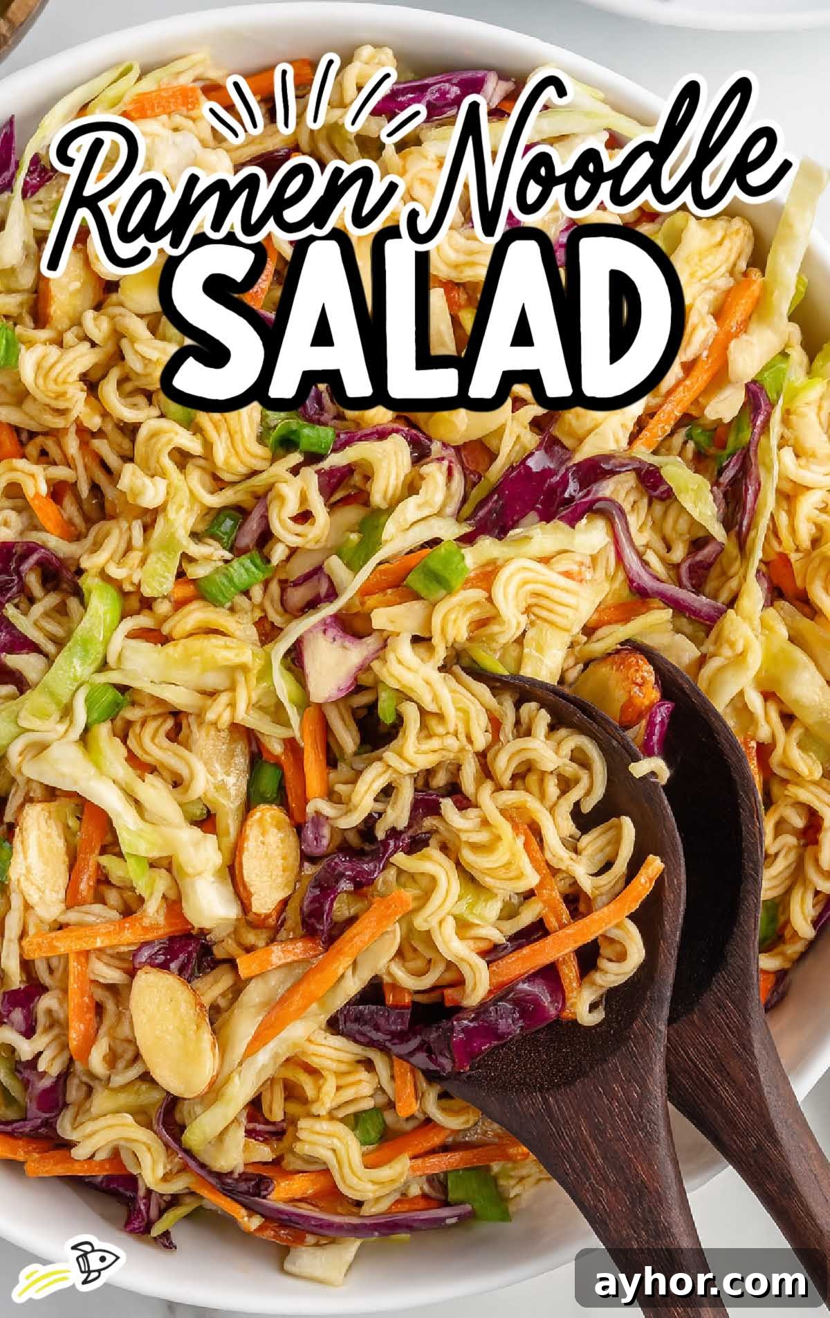 Crunchy Japanese Ramen Noodle Salad with Sesame-Ginger Dressing 2 Close-up of ramen noodle salad with red and green cabbage, matchstick carrots, and wooden serving spoons