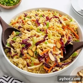 Crunchy Japanese Ramen Noodle Salad with Sesame-Ginger Dressing 7 Bowl of ramen noodle salad with carrots, red cabbage, almonds, and green onions served with wooden spoons