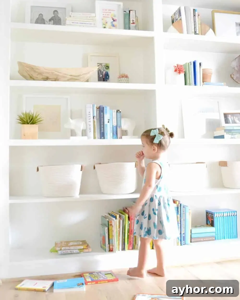 a girl standing in front of shelves showing how to style built in bookcases