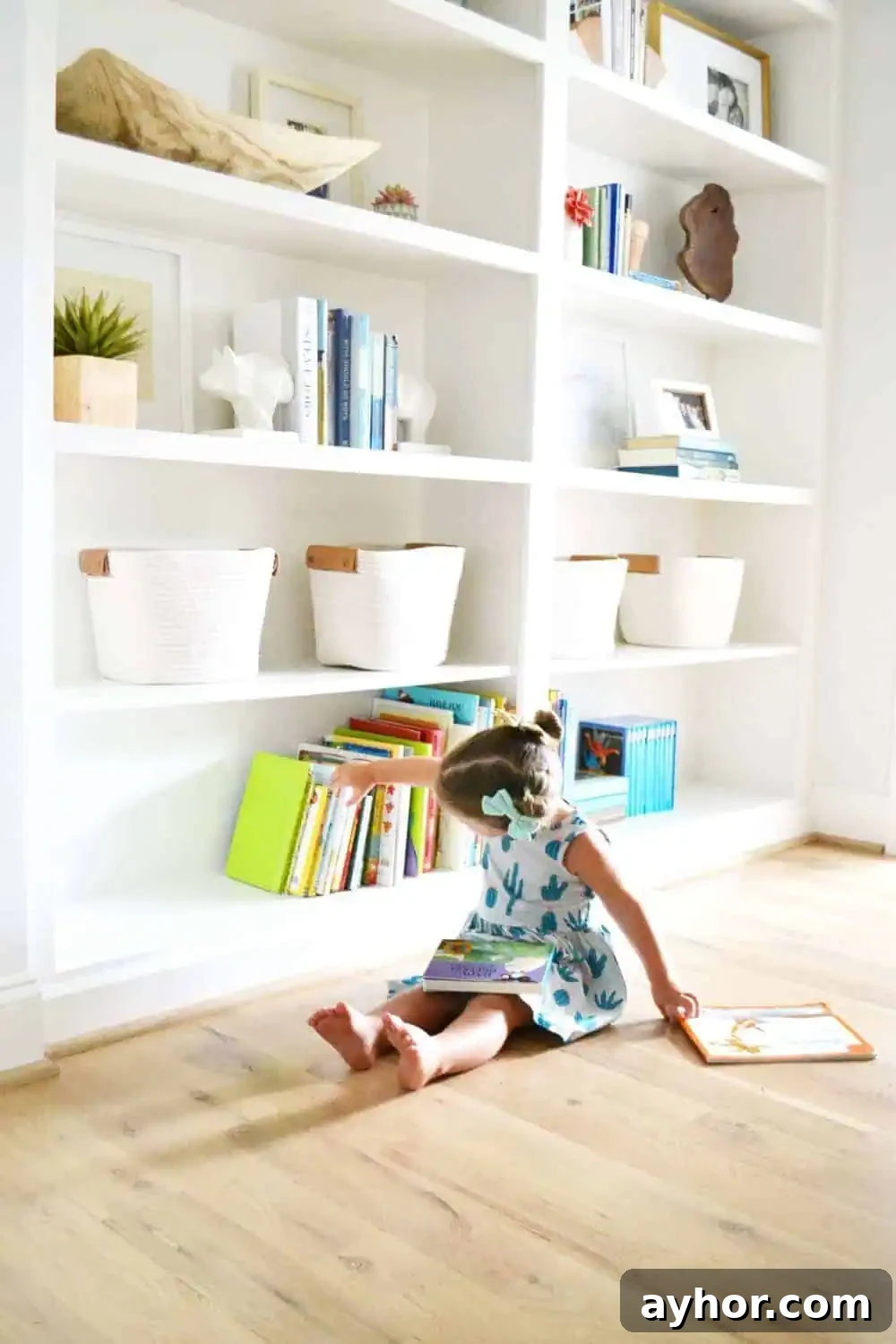 styled built in bookcases with a little girl on the floor