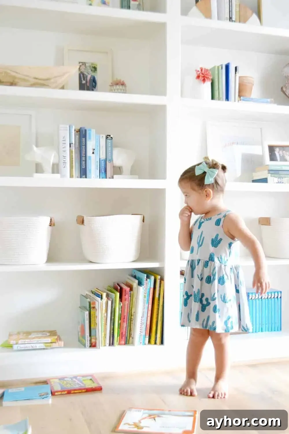 a little girl showing how to style built in bookcases