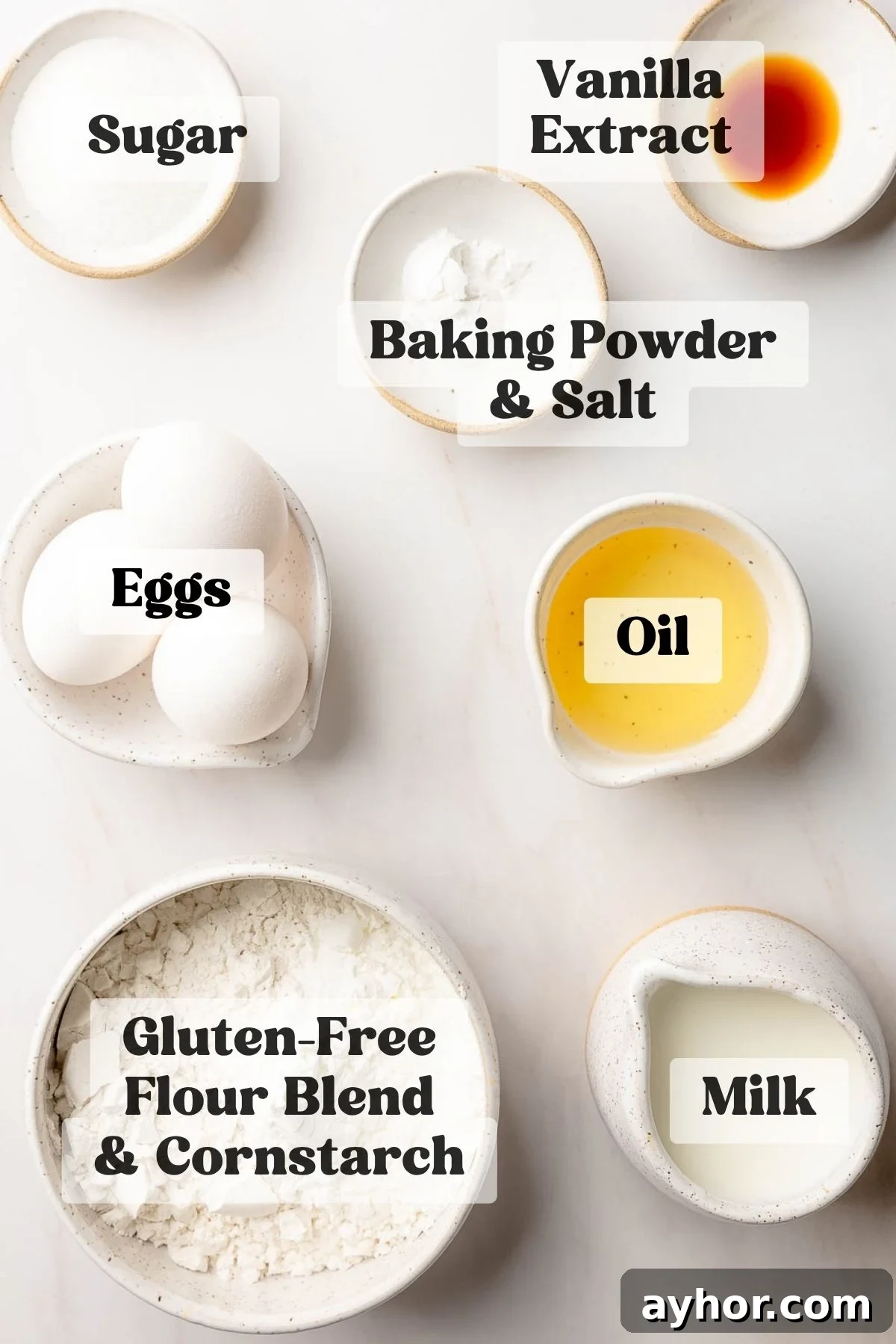 Ingredients for gluten free waffles measured out in bowls on white marble surface.