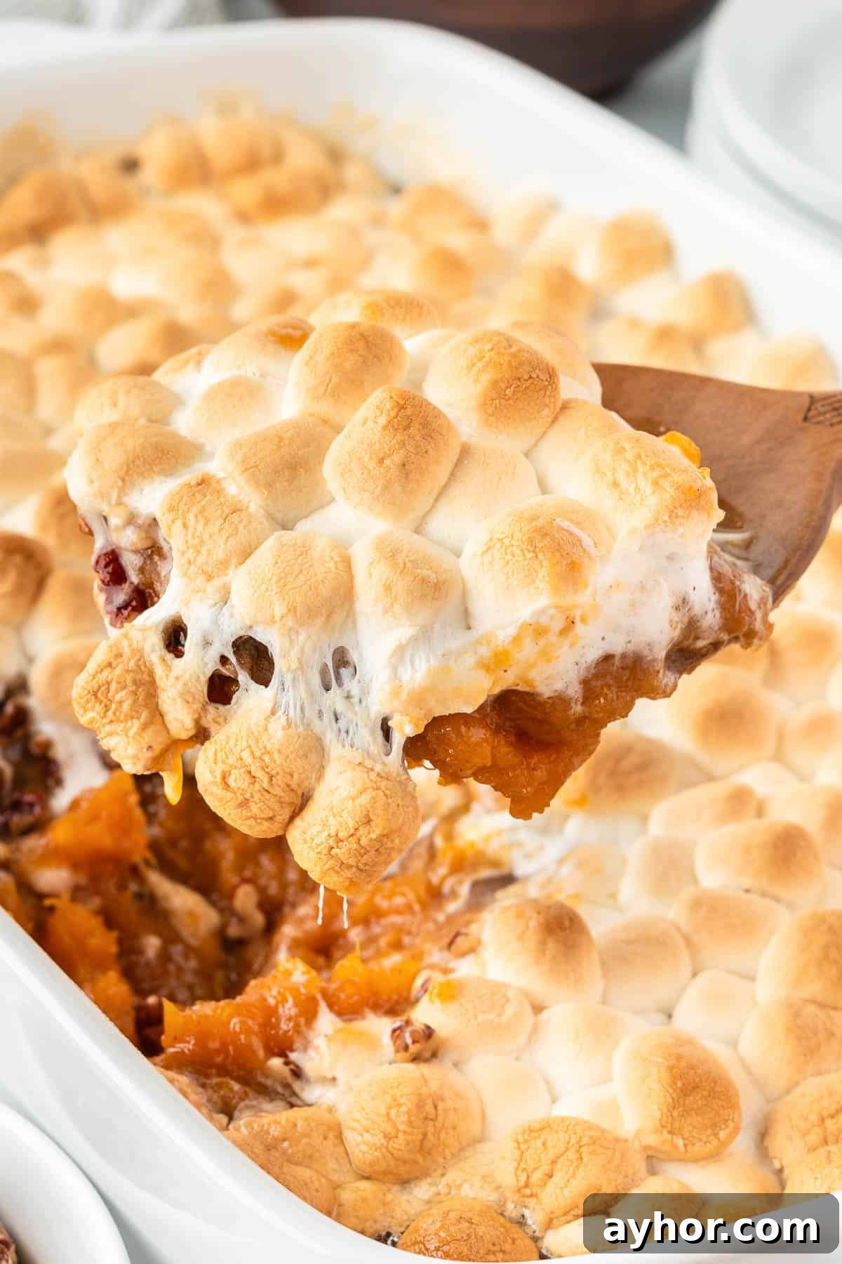 Creamy Sweet Potato Casserole with Toasted Marshmallows 2 scooping sweet potato casserole from the dish