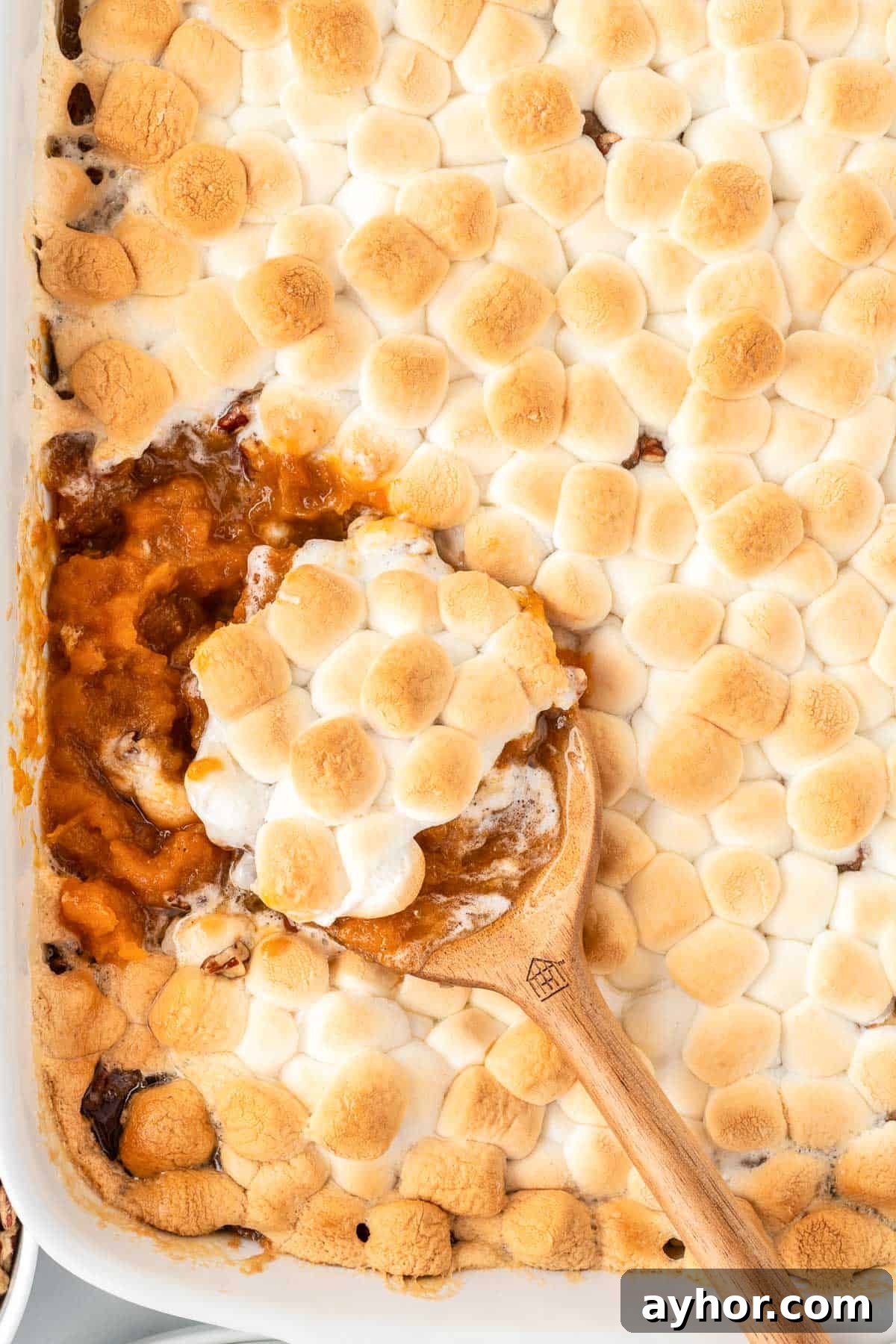 Creamy Sweet Potato Casserole with Toasted Marshmallows 21 scooping sweet potato casserole from the dish