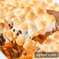 Creamy Sweet Potato Casserole with Toasted Marshmallows 22 scooping sweet potato casserole from the dish