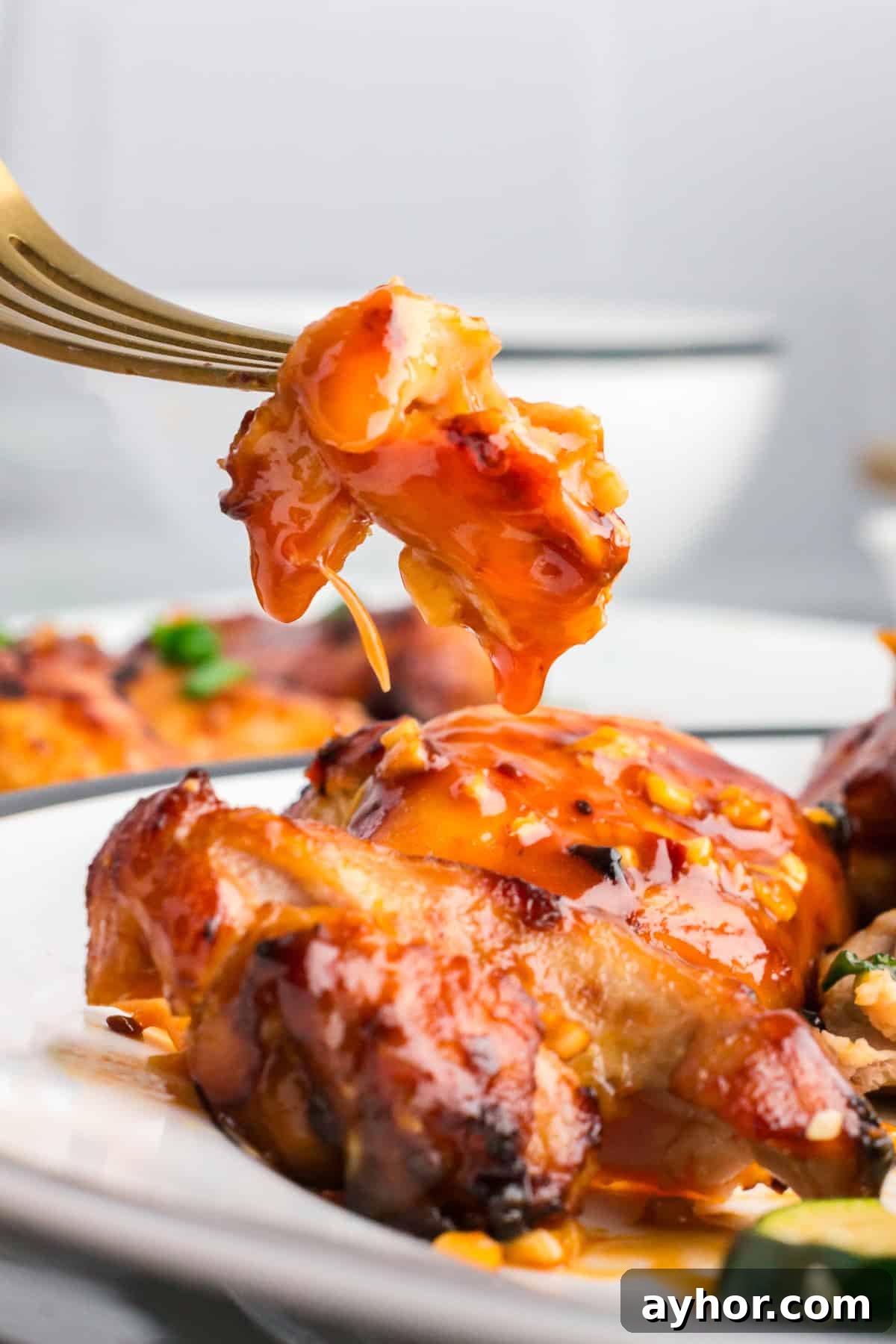 Sticky Air Fryer Chicken Thighs (Oven Method Included) 11 a bite of chicken cut off of a chicken thigh coated in sticky glaze