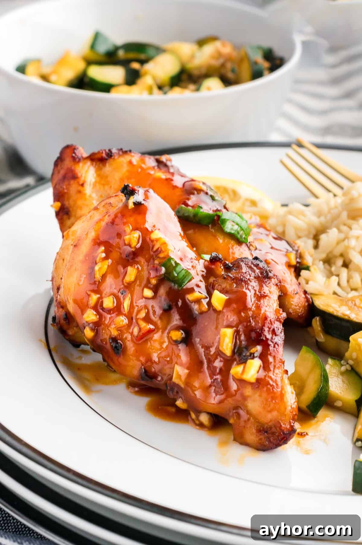 Sticky Air Fryer Chicken Thighs (Oven Method Included) 3 A plate with juicy air fryer chicken thigh, rice and veggies.