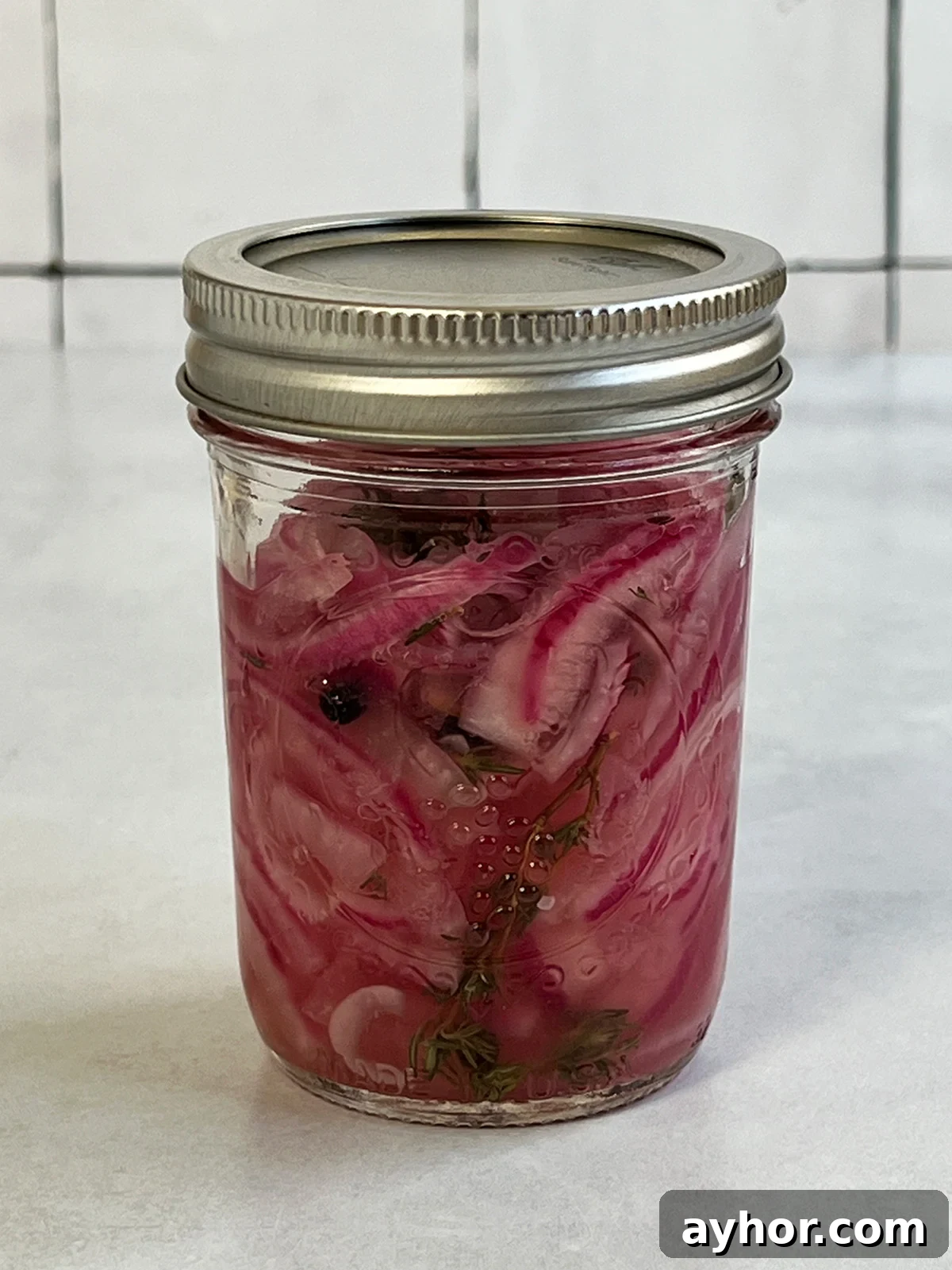 Pickled red onions in a canning jar close up view of some that are ready to eat.