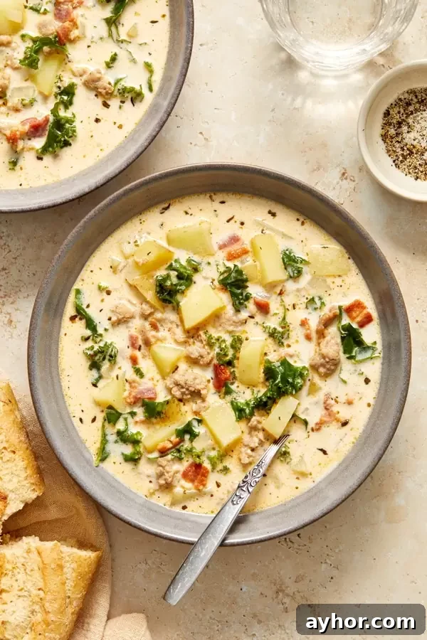 Two bowls of Dairy Free Zuppa Toscana with a spoon in one.