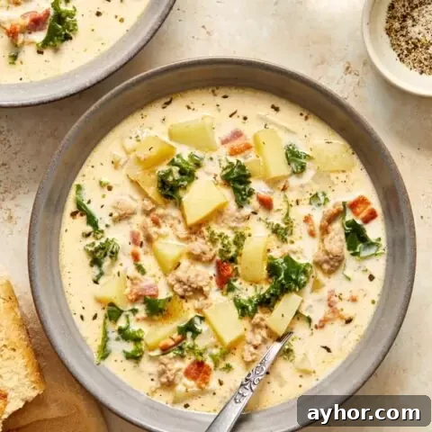 Two bowls of Dairy Free Zuppa Toscana with a spoon in one.