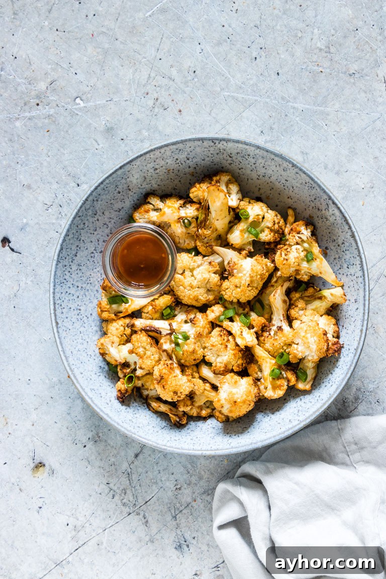 Crispy Air-Fryer Cauliflower Wings with Spicy Dipping Sauce 7 the finished cauliflower wings served in a bowl with a cup of buffalo sauce