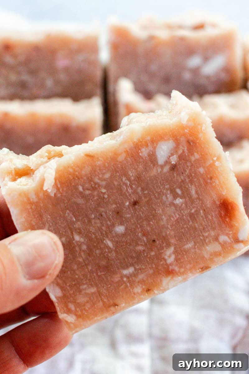 Holding a bar of pink rebatch soap.