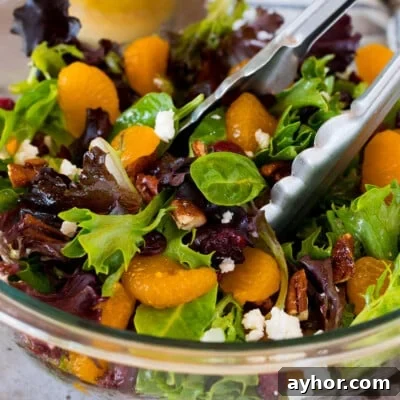 Tongs in a bowl of mandarin orange salad.