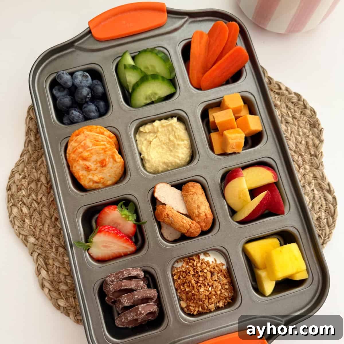 Different snacks arranged in a square muffin baking tray.