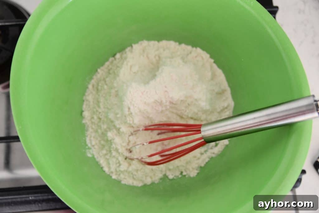 Easter Blondie Bars with Marshmallow Eggs Recipe 4 flour in a green bowl with whisk