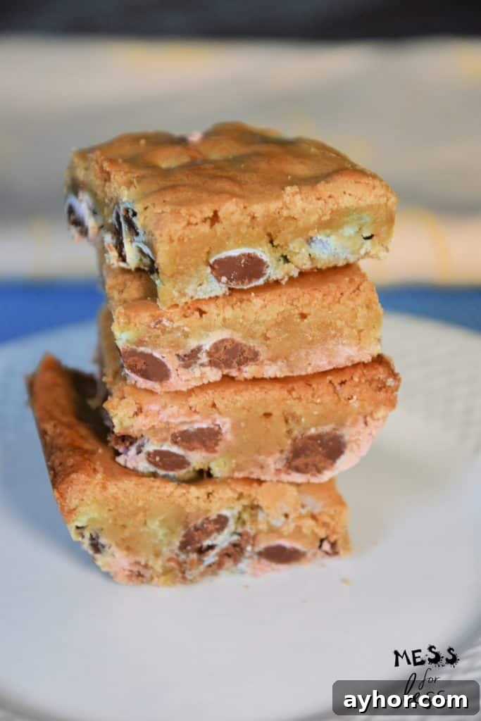 Easter Blondie Bars with Marshmallow Eggs Recipe 8 Stack of chocolate chip Easter blondies on a white plate.